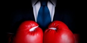 Stock image of person wearing business suit and boxing gloves